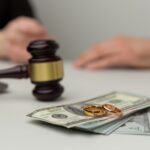 gavel with money and wedding rings in foreground_s