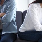 A couple on a couch facing away from eachother_s