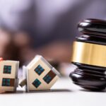 Two toy houses on their sides next to a gavel_s