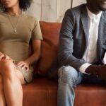 A couple sitting on a couch not happy with eachother_s