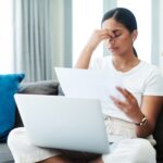 Laptop,,Home,And,Woman,With,Headache,,Documents,And,Stress,With