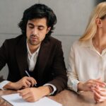 man is signing divorce documents with wife_s