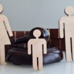 Wooden figures representing a family near a gavel and Law books_s