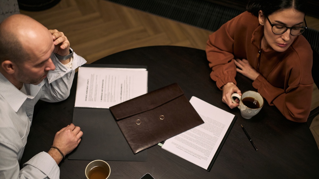 couple reviewing divorce papers and wedding rings